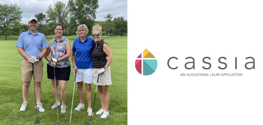 A group of four golfers pose together on the green during the 2024 Cassia Golf Tournament. They are smiling and holding their clubs, dressed in casual golf attire, with trees and a bright green course in the background.
