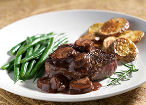 Chef-inspired meal on a plate with roasted potatoes, green beans and a glazed meat dish.
