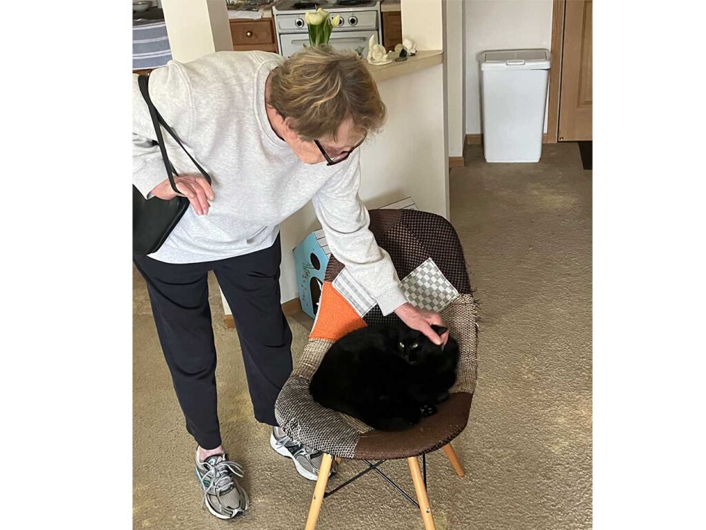 Sheri pets her black cat Sonny in their pet-friendly apartment at The Pines of Richfield, where cats and small dogs are welcome.