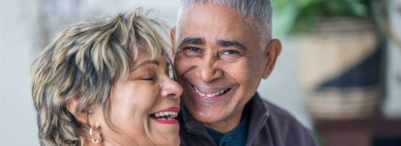 Two older adults smiling together in a close portrait, representing a joyful senior living lifestyle like The Pines of Richfield in Richfield, Minnesota