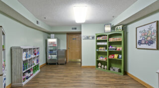 On-site pantry store with shelves of snacks, beverages, and household items in a community space at The Pines of Richfield in Richfield, Minnesota