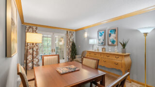 Private dining or meeting room with table, chairs, sideboard, and decorative wall art with access to a patio at The Pines of Richfield in Richfield, Minnesota