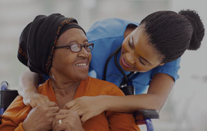 A senior receiving supportive care from a caregiver in a comfortable setting, representing personalized care services like The Pines of Richfield in Richfield, Minnesota